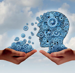 Training and development business education concept with a hand holding a group of gears transfering the wheels of knowledge to a human head made of cogs as a symbol of acquiring the tools for career learning.